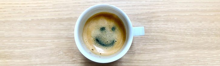 Tasse mit Kaffee; in der Crema ist ein Smiley